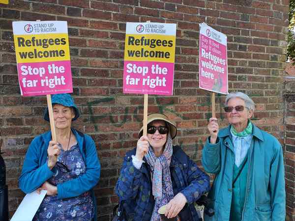 three women stand up to racism banners 20250822 175048